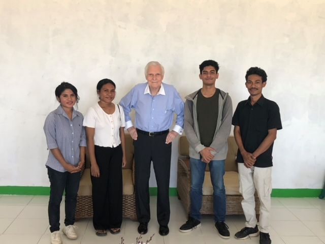 Professor Herbert Davis stands for a photo with several students at the Joao Saldanha University. 