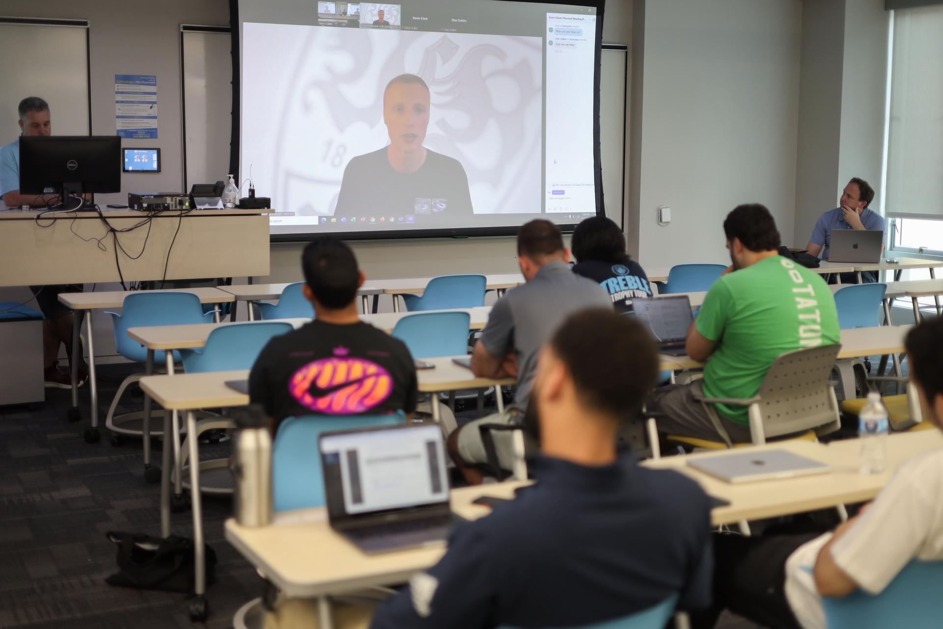 Scott Rezendes Zooms into a classroom full of students who watch him on the projector