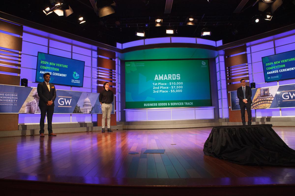 The annual NVC awards ceremony takes place in Jack Morton Auditorium, where the winners of the four vertical tracks find out their placements and prizes. Image shows three GW students on stage during the 2024 New Venture Competition.