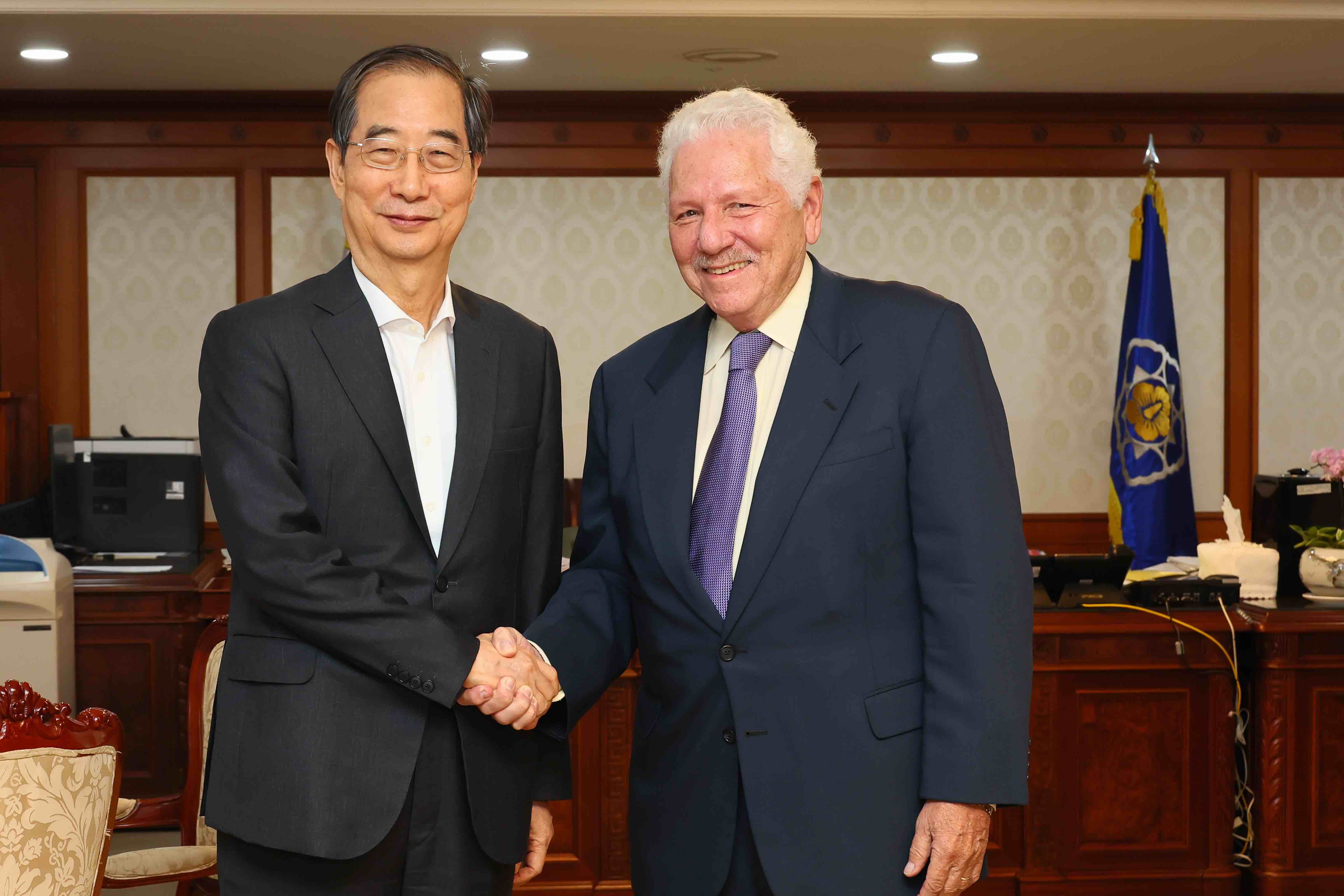 Prime Minister Han Duck-soo (left) shakes hands with Danny Leipziger
