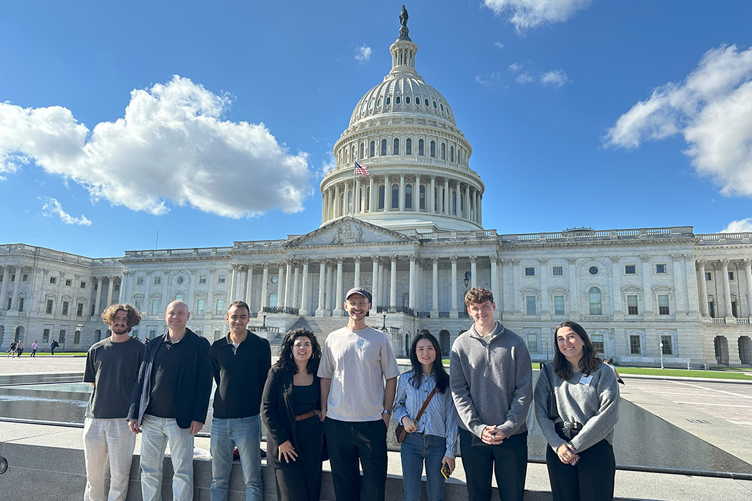 Graduate-level exchange students from GWSB partner institutions pose for a photo in front of the U.S. Capitol building on a sunny day