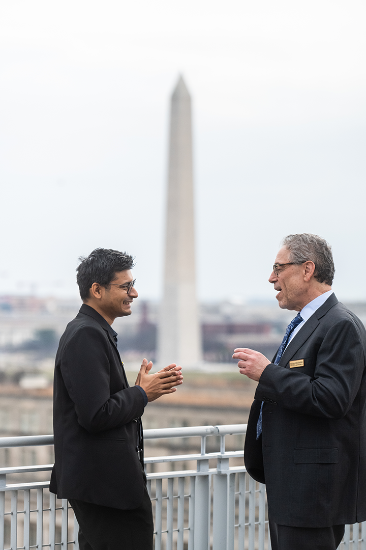 Two people discussing with the washington monument in the background