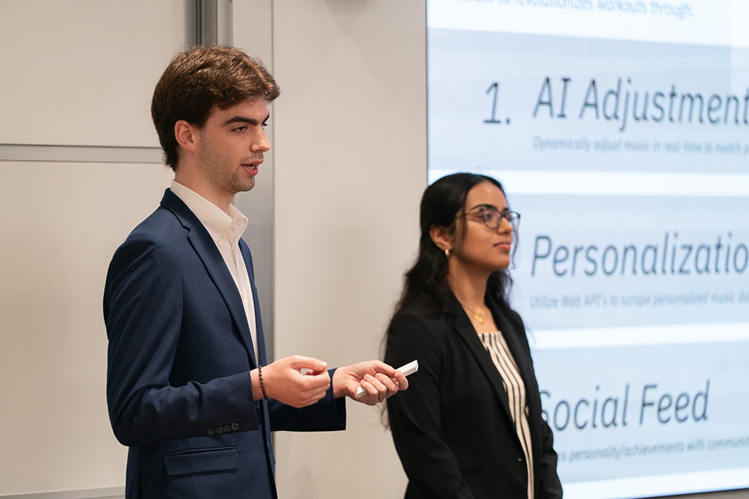 Two students speaking in front of presentation