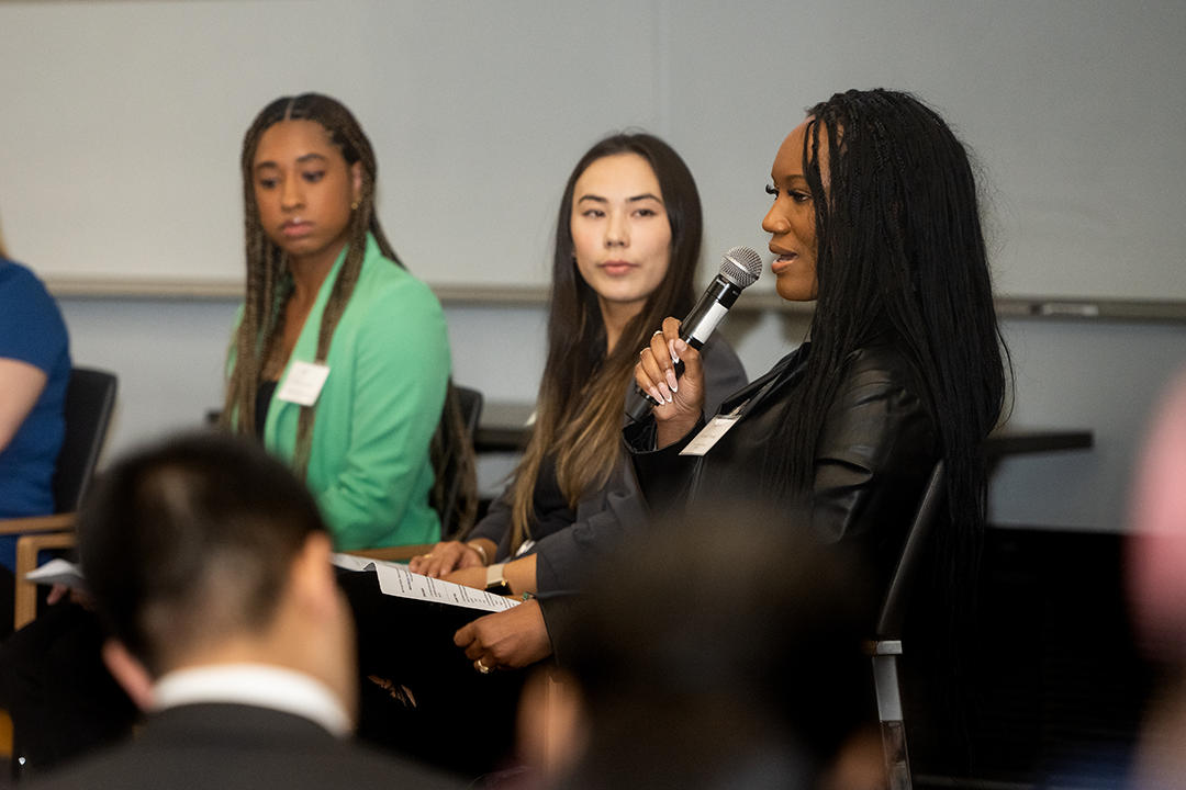 person in business attire speaks with microphone