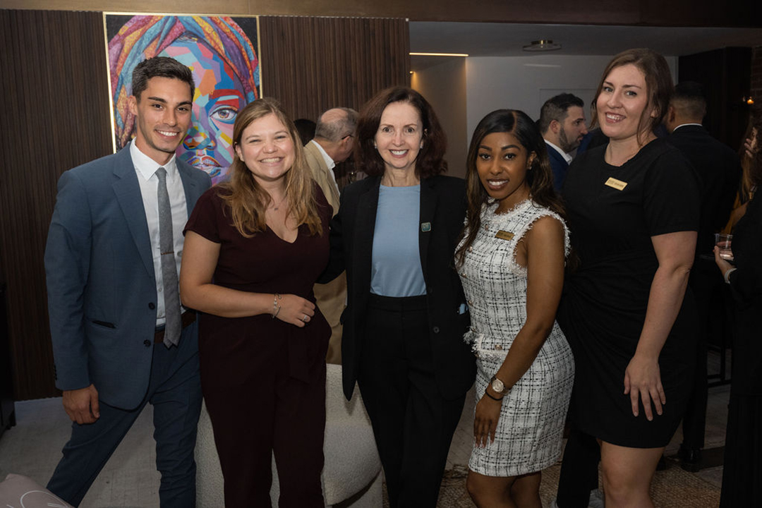 four students pose for a photo with Kathleen Duffy, Senior Director of Career Development, during a GWSB career center networking event
