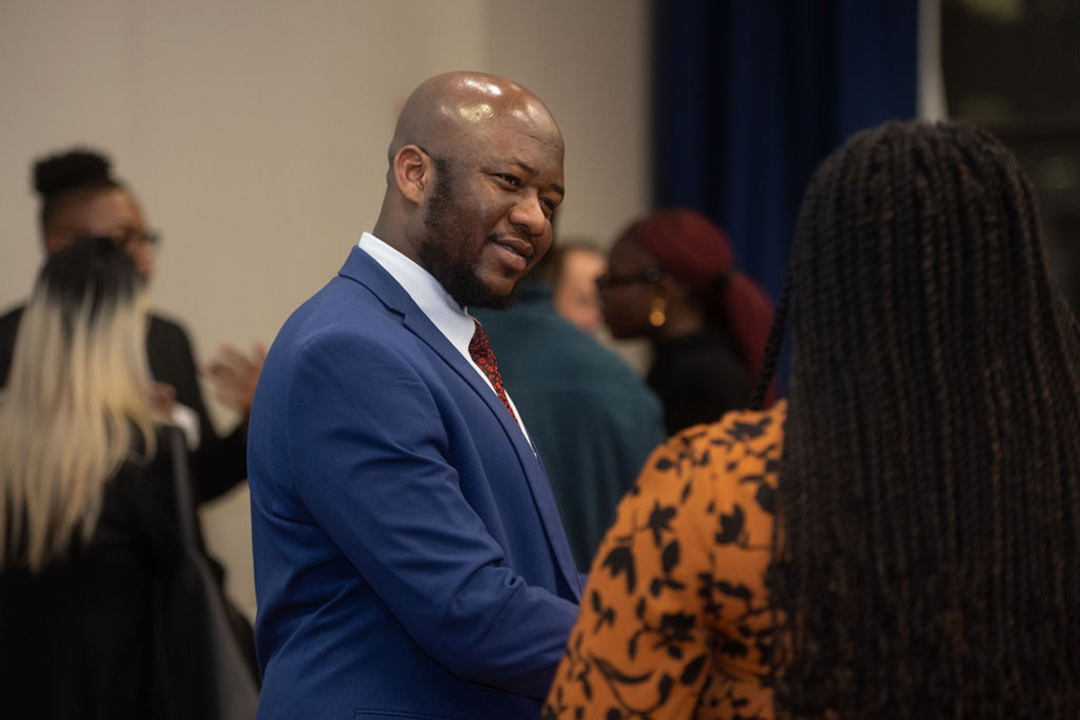 a smiling man and a woman chat at a GWSB recruting event