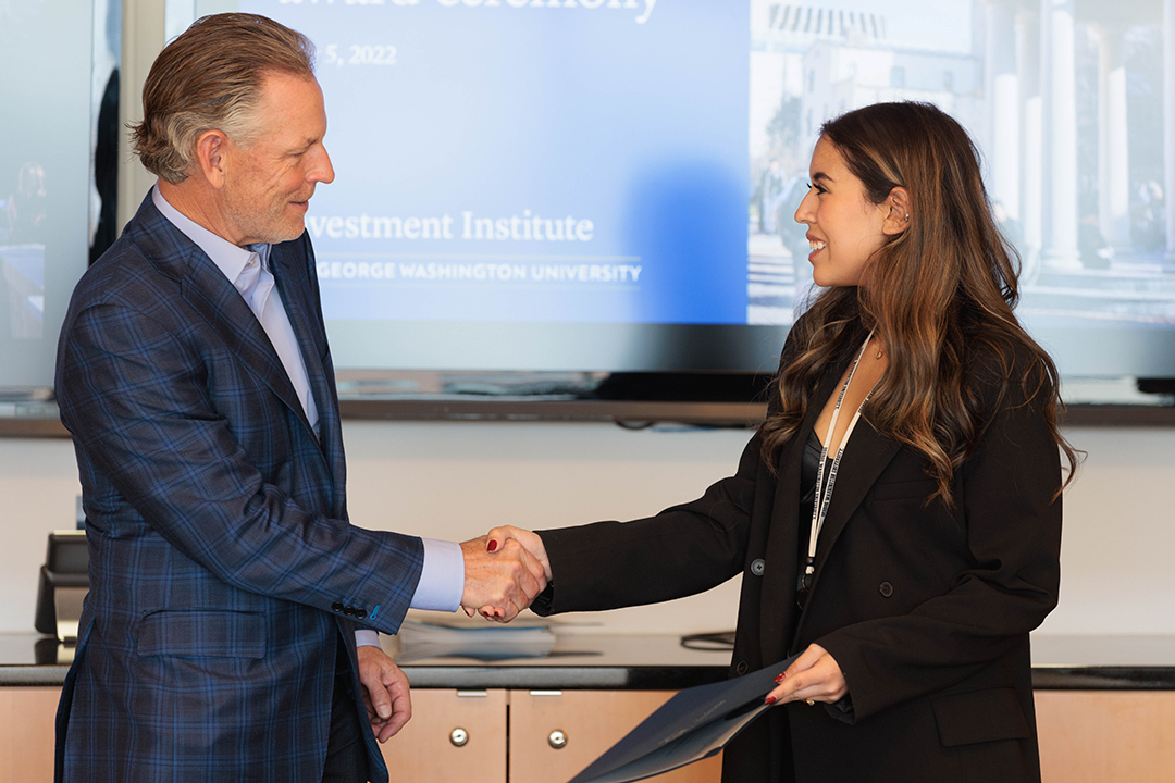 a GWSB student shakes hands with a recruiter at a career center event