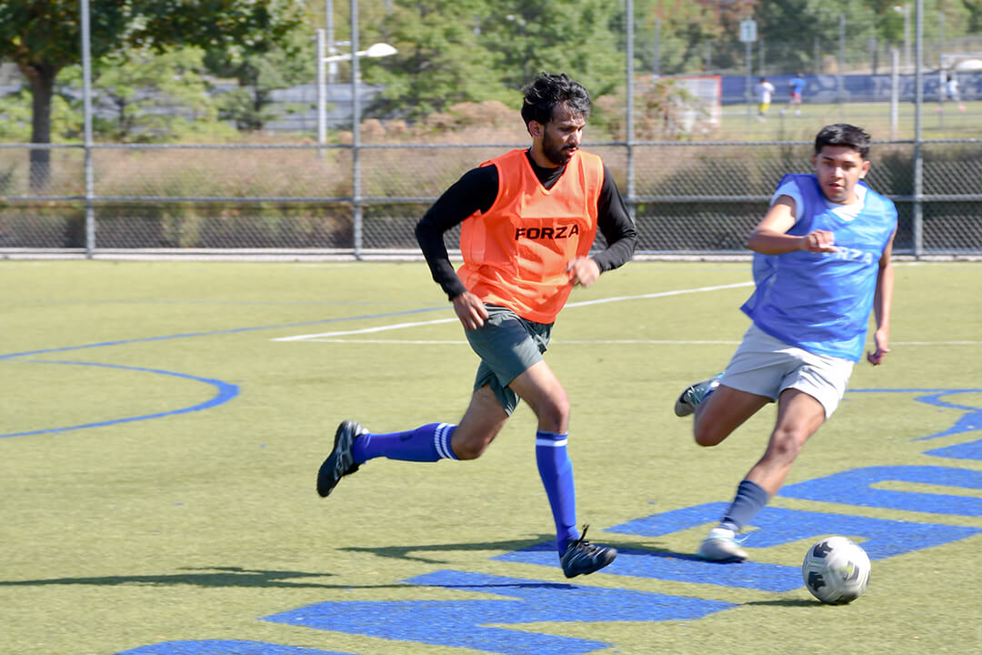 one player from the orange and blue teams go after the ball during the inaugural Buff & Blue Cup