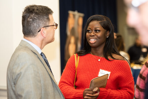 student speaks to a professional at a networking event