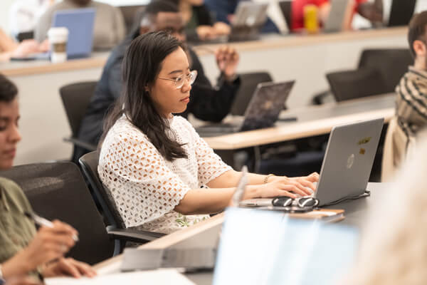 student works on laptop in classroom