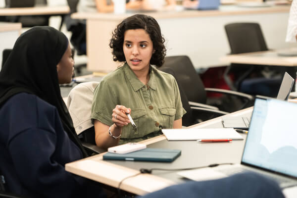 two students collaborate during class