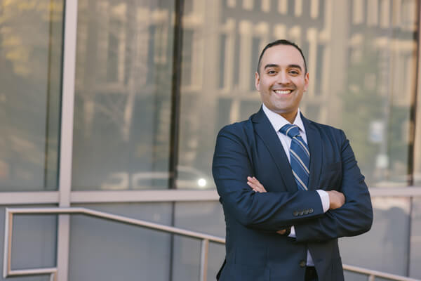 GW Business student, dressed in professional attire, smiles at the camera