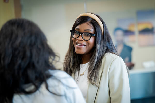 two students in conversation, one has back to camera