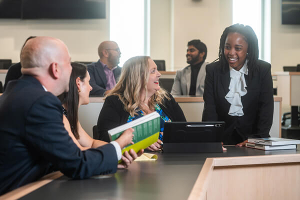 business students speak to faculty in classroom