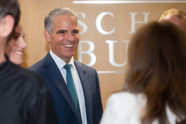 faculty member smiles at person with their back to camera