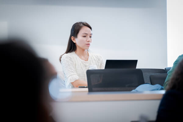 student works on laptop in classroom