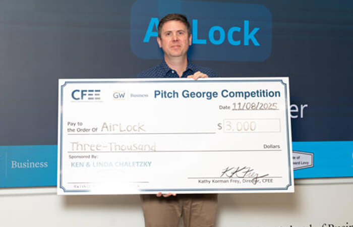 Member of Airlock group holds check for $3000