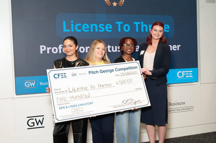 4 members of the License to Thrive group pose with a large check for $500