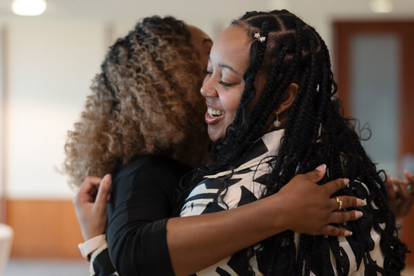 two business students hug each other