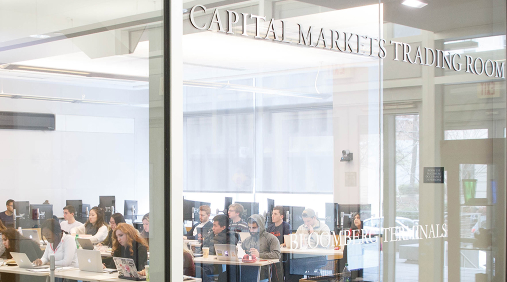 students attend a GW Investment Institute class in the Capital Markets Trading Room in Duquès Hall