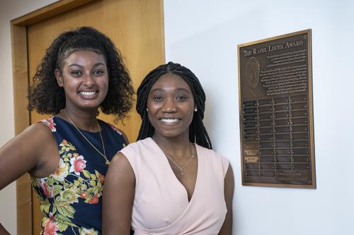 Rafel Lucea Global Experiential Fund students at GWSB pose next to a bronze plaque