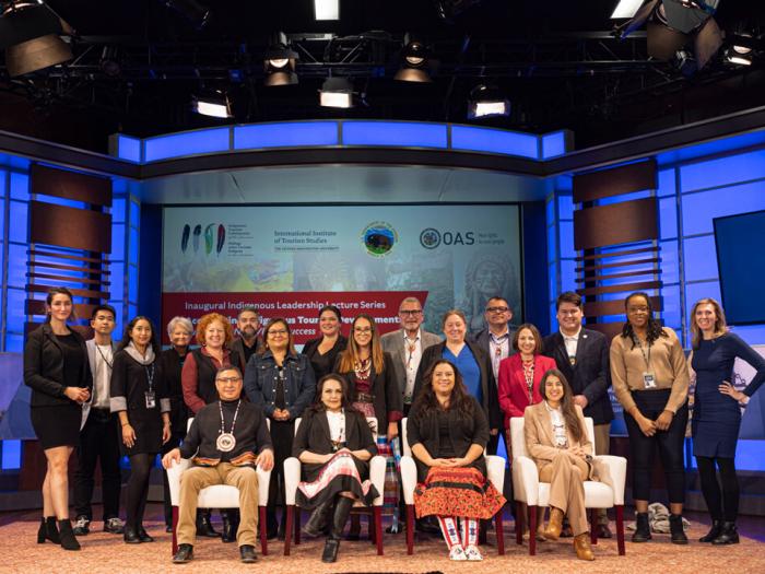 A large group of people, participants and others associated with the Distinguished Indigenous Leaders Lecture Series, pose for a photo.