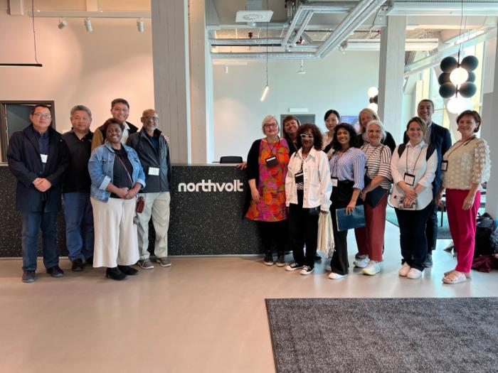 A group of people in a large office lobby in front of a desk with the text "Northvolt." 