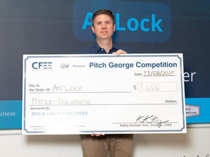 Member of Airlock group holds check for $3000