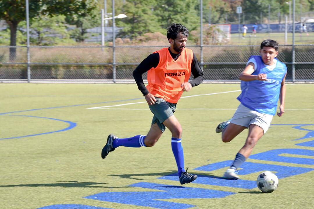 one player from the orange and blue teams go after the ball during the inaugural Buff & Blue Cup