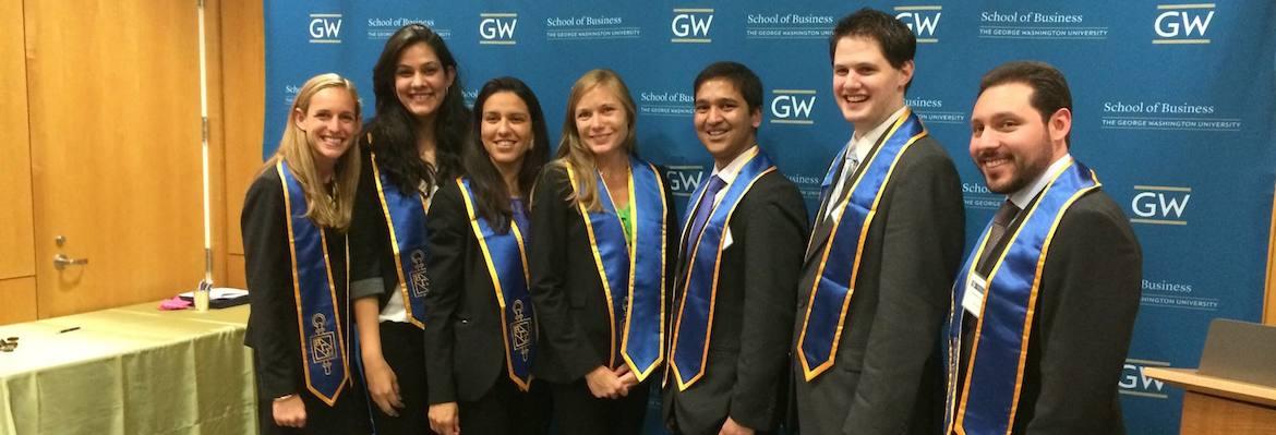 Beta Gamma Sigma members pose together for a photo in graduation regalia