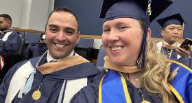 Guadalupe Vega, M.S. ‘23, a U.S. Army veteran, and Rebecca Strang, M.S. '23, a military spouse, both graduates of the Master of Human Resource Management (MHRM) program at the GW School of Business., posing for a selfie during graduation.  