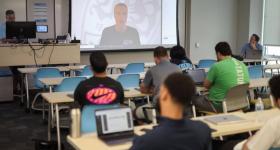 Scott Rezendes Zooms into a classroom full of students who watch him on the projector