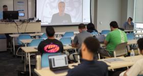 Scott Rezendes Zooms into a classroom full of students who watch him on the projector