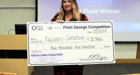 Krystl Haerien holding her oversized check for $2,500.