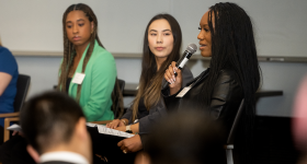 person in business attire speaks with microphone